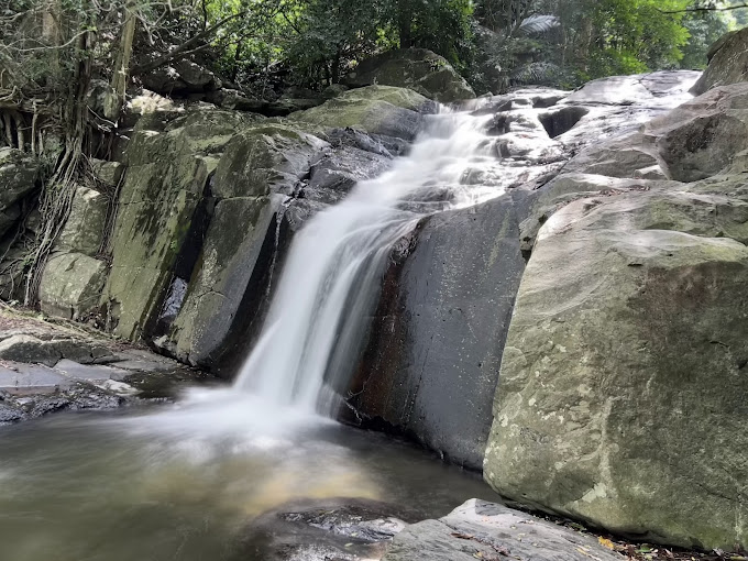 Water cascading over smooth rocks in the forest at Pala-U Waterfall