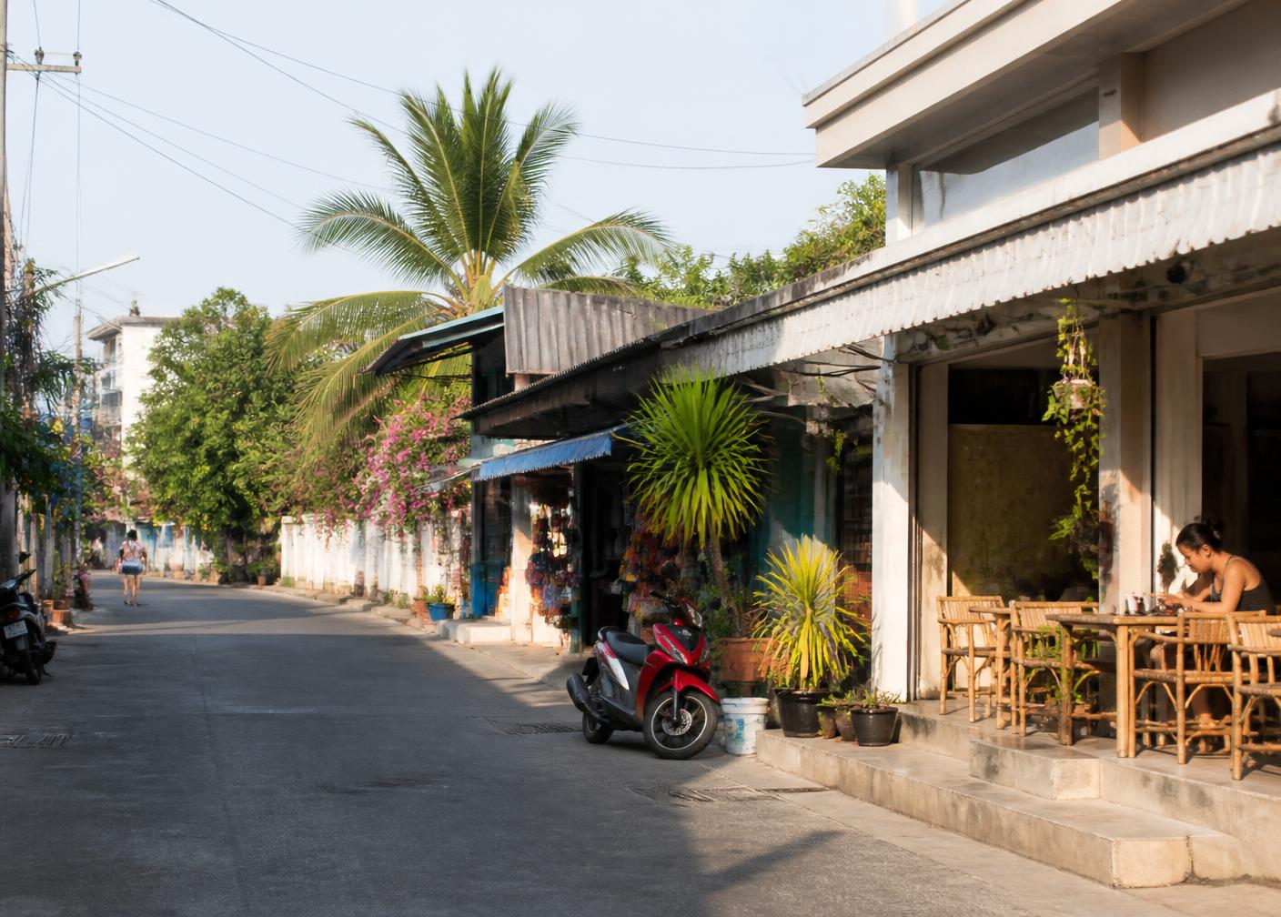A quiet residential street in Hua Hin with local shops and a small café in the morning