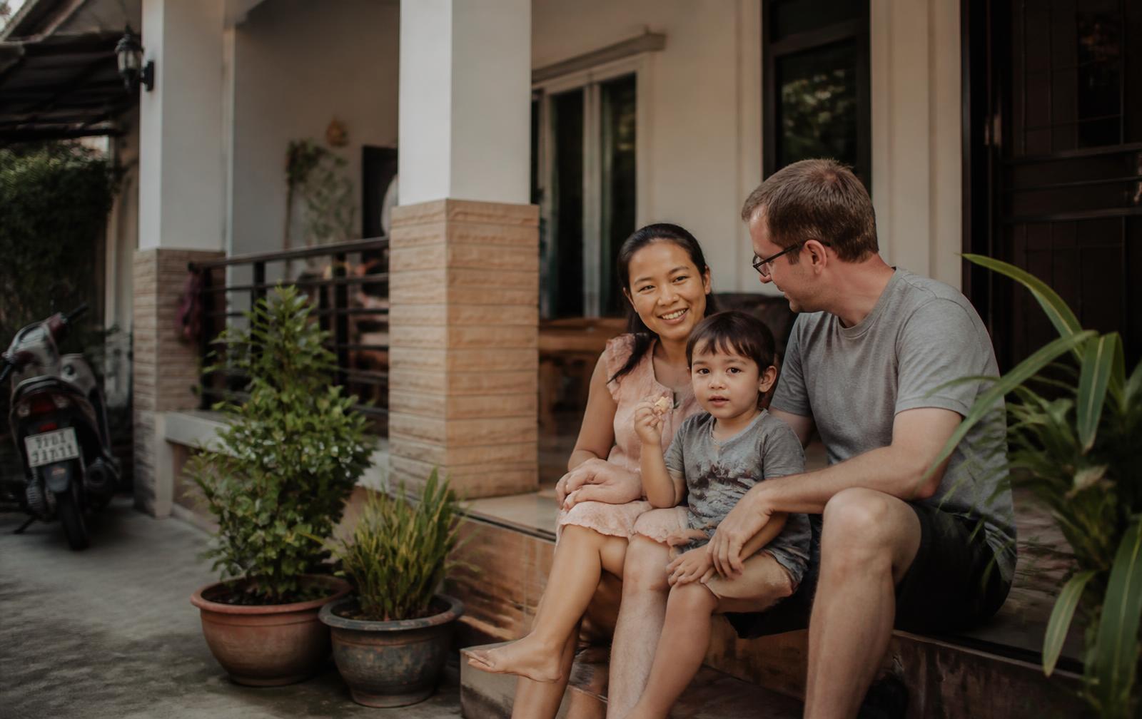 A Thai and foreign couple with their young child on the terrace of their home in a Hua Hin residential street